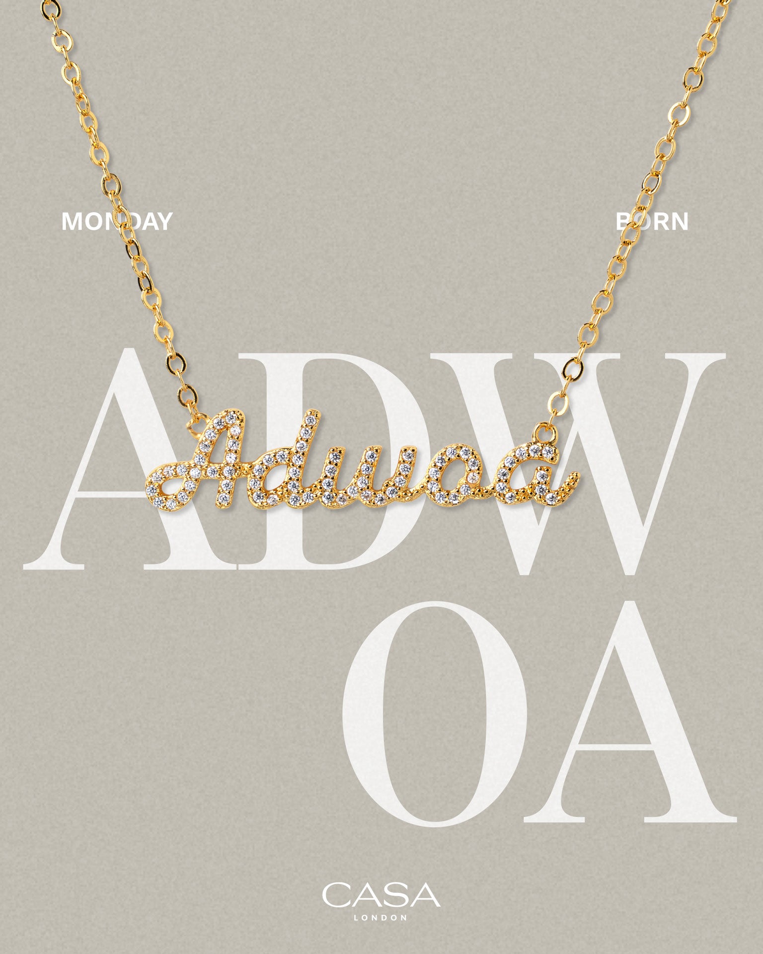 A product shot of CASA London’s 18k gold Adwoa Pavé Necklace. The delicate gold chain features a script pendant spelling "Adwoa," encrusted with shimmering pavé-set stones against a neutral, textured background. Overlaid text reads "MONDAY BORN," highlighting the brand's commitment to celebrating cultural heritage and personal narratives through modern luxury.