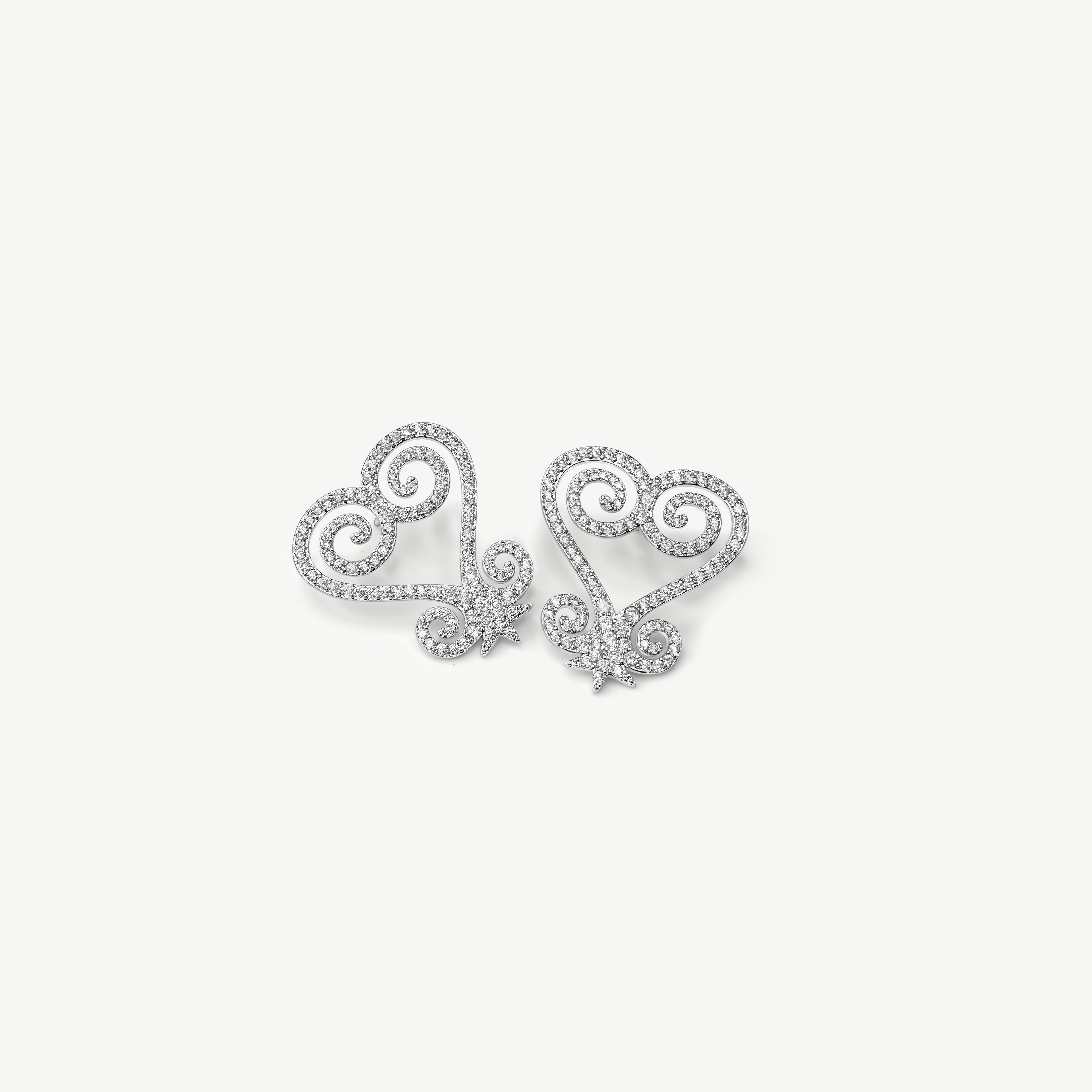 A product shot of CASA London's silver Sankofa Pavé earrings displayed on a clean white background. One earring is shown from the front and the other from the back, highlighting the intricate heart-shaped Sankofa Adinkra symbol meticulously encrusted with shimmering pavé-set stones. This display showcases the brand's unwavering commitment to superior craftsmanship and modern luxury design.